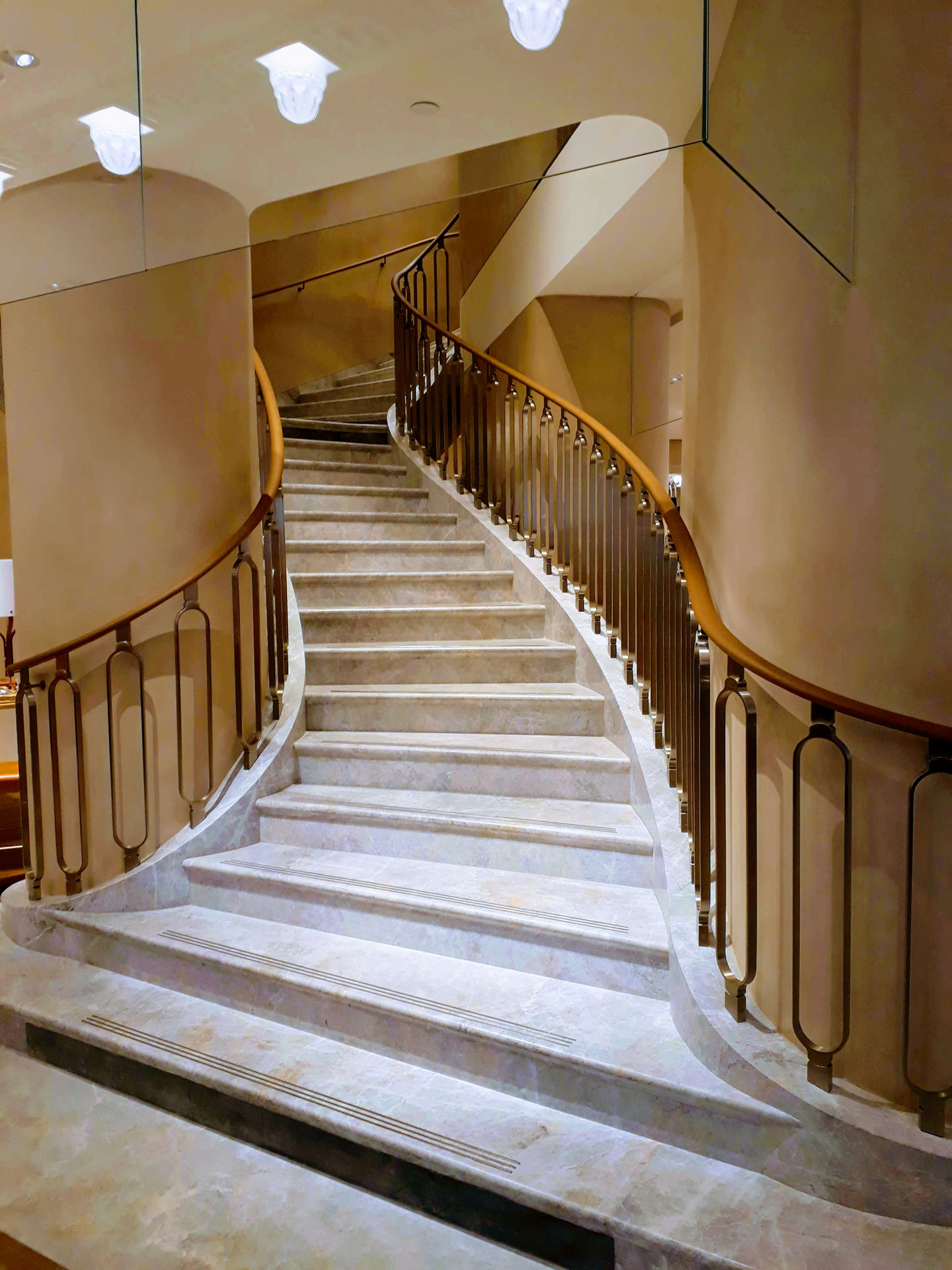 Photo d'un escalier avec une rampe débillardée, main courante en tilleul gainée de cuir pour Hermès